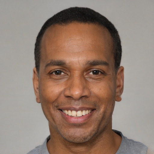 Joyful black adult male with short  black hair and brown eyes