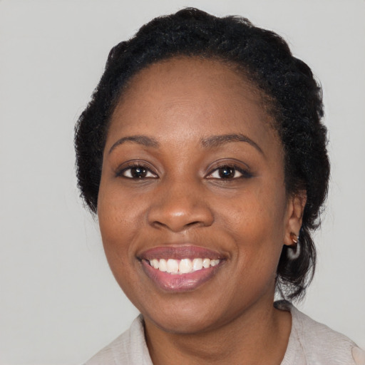 Joyful black adult female with medium  black hair and brown eyes