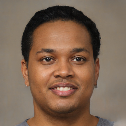 Joyful black young-adult male with short  brown hair and brown eyes