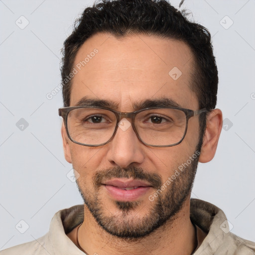 Joyful white adult male with short  black hair and brown eyes