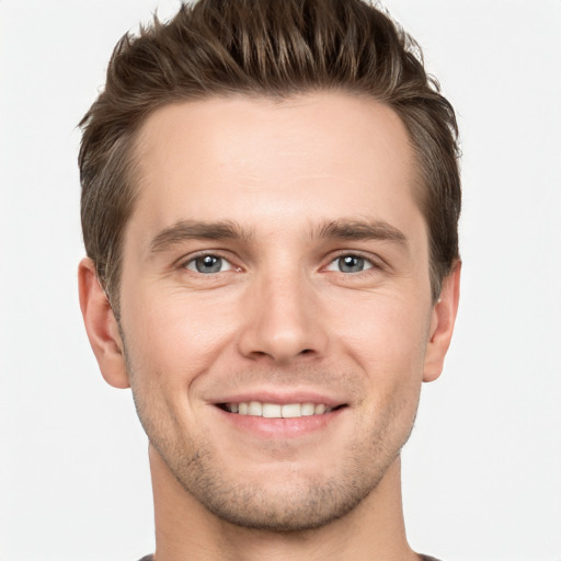 Joyful white young-adult male with short  brown hair and grey eyes