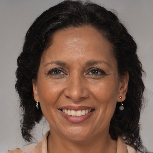 Joyful black adult female with medium  brown hair and brown eyes