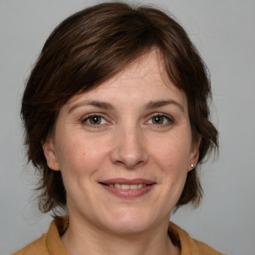 Joyful white adult female with medium  brown hair and grey eyes