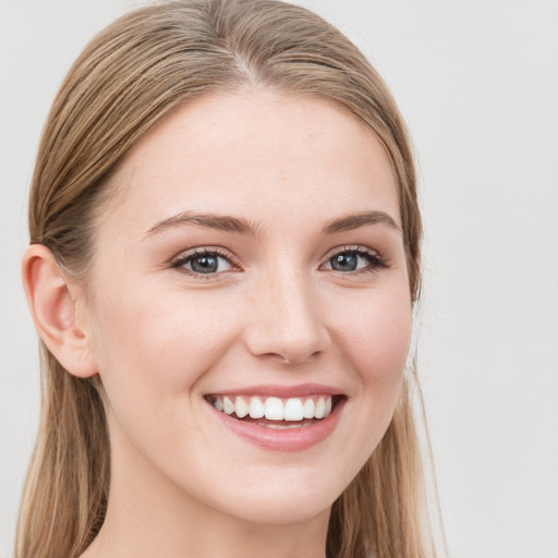 Joyful white young-adult female with long  brown hair and blue eyes