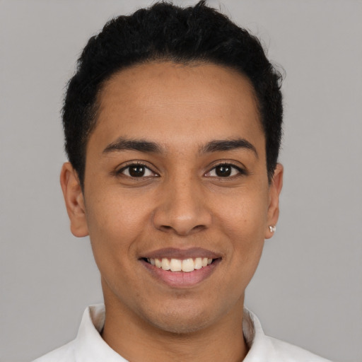 Joyful latino young-adult male with short  black hair and brown eyes