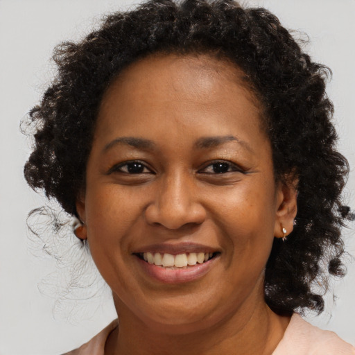 Joyful black adult female with long  brown hair and brown eyes