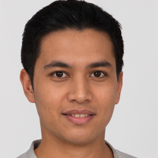 Joyful latino young-adult male with short  black hair and brown eyes