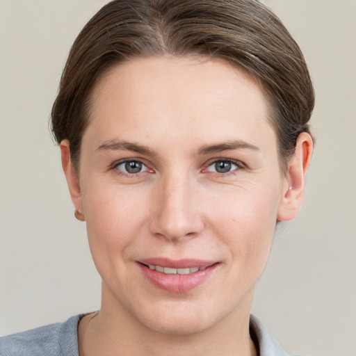 Joyful white young-adult female with short  brown hair and grey eyes