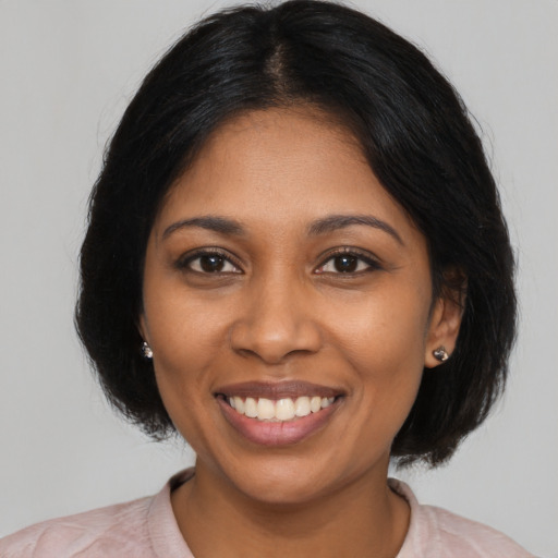 Joyful black young-adult female with medium  black hair and brown eyes