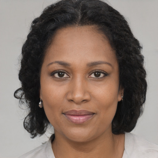 Joyful black adult female with medium  brown hair and brown eyes