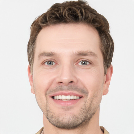 Joyful white young-adult male with short  brown hair and grey eyes