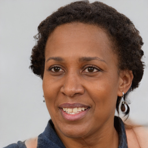 Joyful black adult female with medium  brown hair and brown eyes