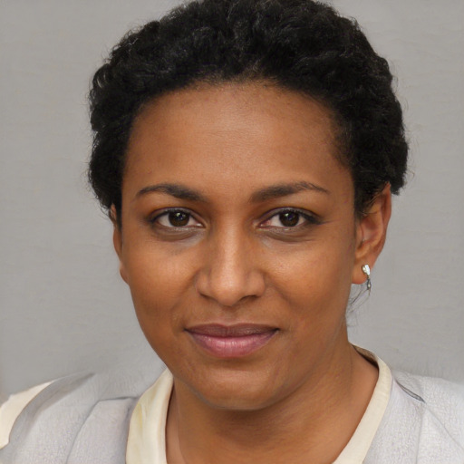 Joyful black young-adult female with short  brown hair and brown eyes