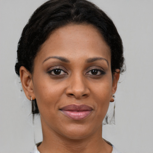 Joyful black adult female with medium  brown hair and brown eyes