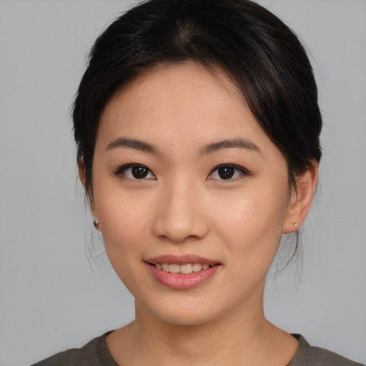 Joyful asian young-adult female with medium  brown hair and brown eyes