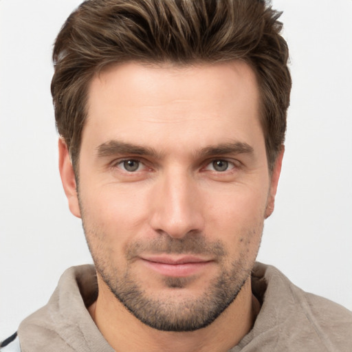 Joyful white young-adult male with short  brown hair and grey eyes