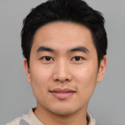 Joyful asian young-adult male with short  black hair and brown eyes