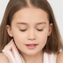 Joyful white child female with long  brown hair and brown eyes