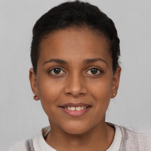Joyful black young-adult female with short  brown hair and brown eyes