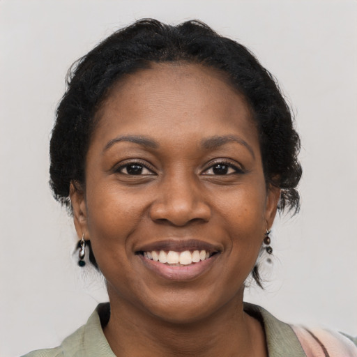 Joyful black young-adult female with medium  brown hair and brown eyes