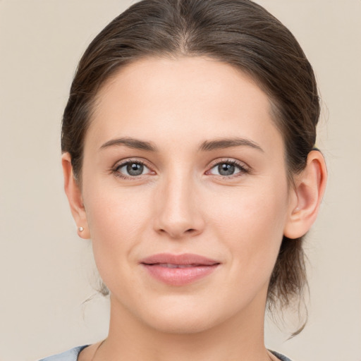 Joyful white young-adult female with medium  brown hair and grey eyes