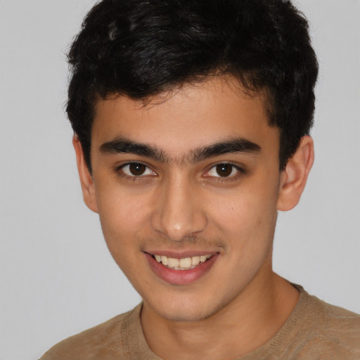 Joyful latino young-adult male with short  brown hair and brown eyes