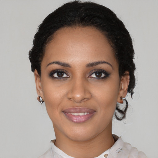 Joyful black young-adult female with short  black hair and brown eyes