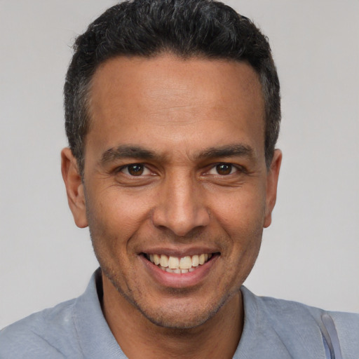 Joyful latino adult male with short  black hair and brown eyes