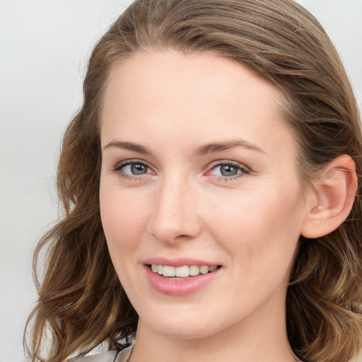 Joyful white young-adult female with long  brown hair and blue eyes