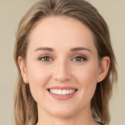 Joyful white young-adult female with long  brown hair and green eyes