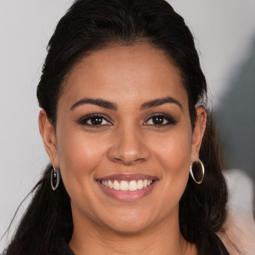 Joyful latino young-adult female with long  brown hair and brown eyes