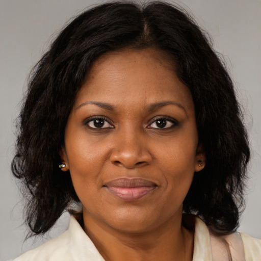 Joyful black adult female with medium  brown hair and brown eyes