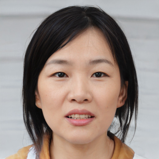 Joyful white young-adult female with medium  black hair and brown eyes