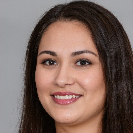 Joyful white young-adult female with long  brown hair and brown eyes