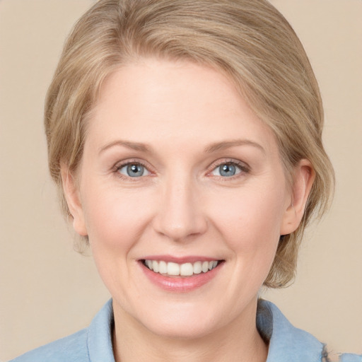 Joyful white adult female with medium  brown hair and blue eyes