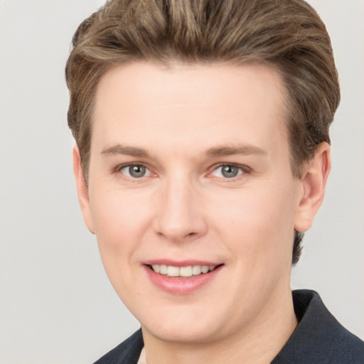 Joyful white young-adult male with short  brown hair and grey eyes