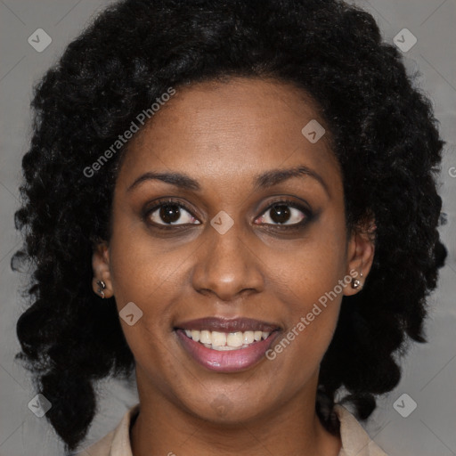 Joyful black young-adult female with long  black hair and brown eyes