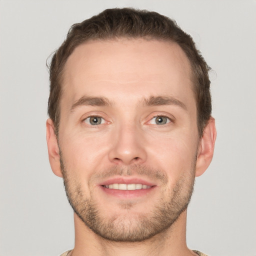 Joyful white young-adult male with short  brown hair and grey eyes