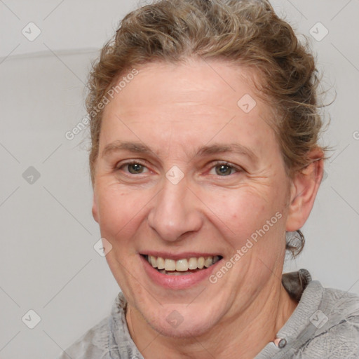 Joyful white adult female with medium  brown hair and blue eyes