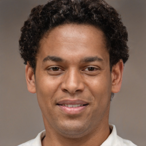 Joyful latino young-adult male with short  brown hair and brown eyes
