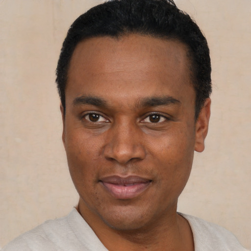 Joyful black young-adult male with short  black hair and brown eyes