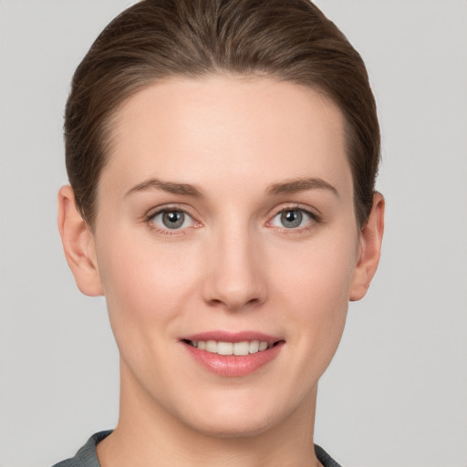 Joyful white young-adult female with short  brown hair and grey eyes