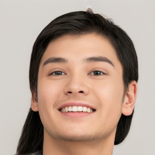 Joyful white young-adult male with long  black hair and brown eyes