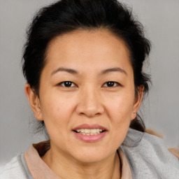 Joyful asian adult female with medium  brown hair and brown eyes