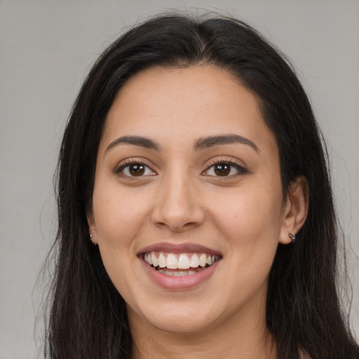 Joyful latino young-adult female with long  brown hair and brown eyes