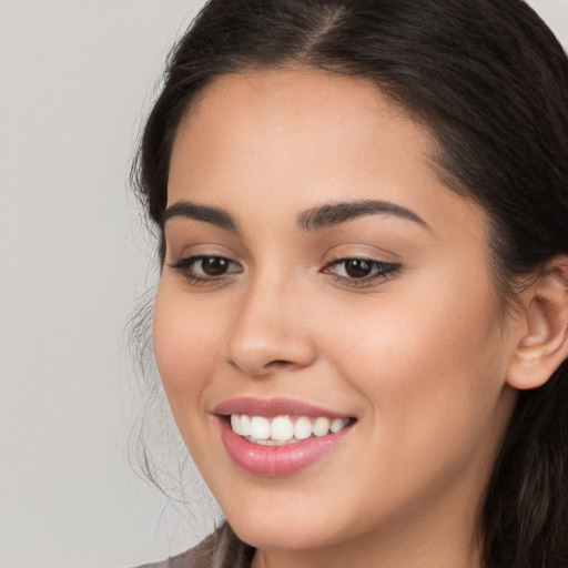 Joyful white young-adult female with long  brown hair and brown eyes