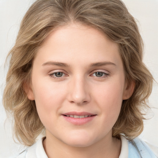 Joyful white young-adult female with medium  brown hair and blue eyes