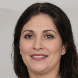 Joyful white adult female with long  brown hair and brown eyes