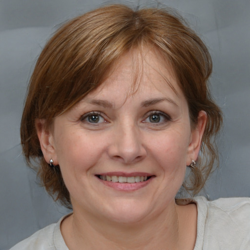 Joyful white adult female with medium  brown hair and grey eyes