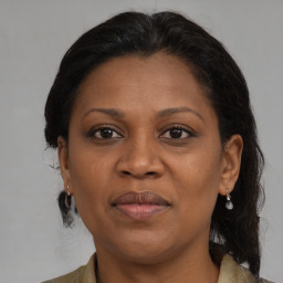 Joyful black adult female with medium  brown hair and brown eyes